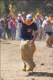 photo showing one of ICC's kids participating in a gunny sack race while attending the 2013 Pathfinder Camporee for Pathfinder clubs in Central America